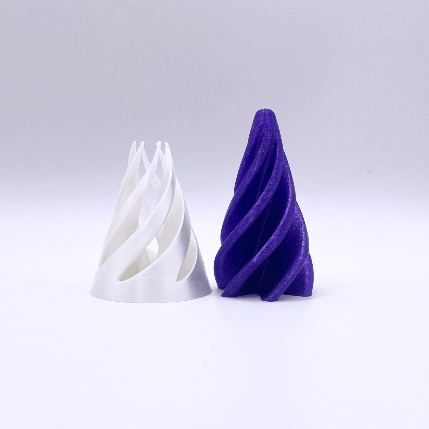 Galaxy Swirl Fidgets White and purple spiral-shaped fidget toy on a light grey background