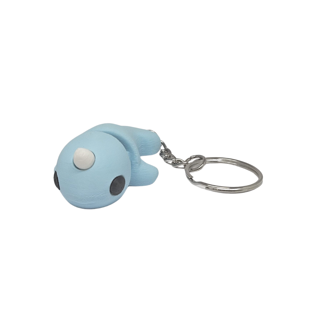 A blue narwhal whale keyring with a keychain, against a white background.