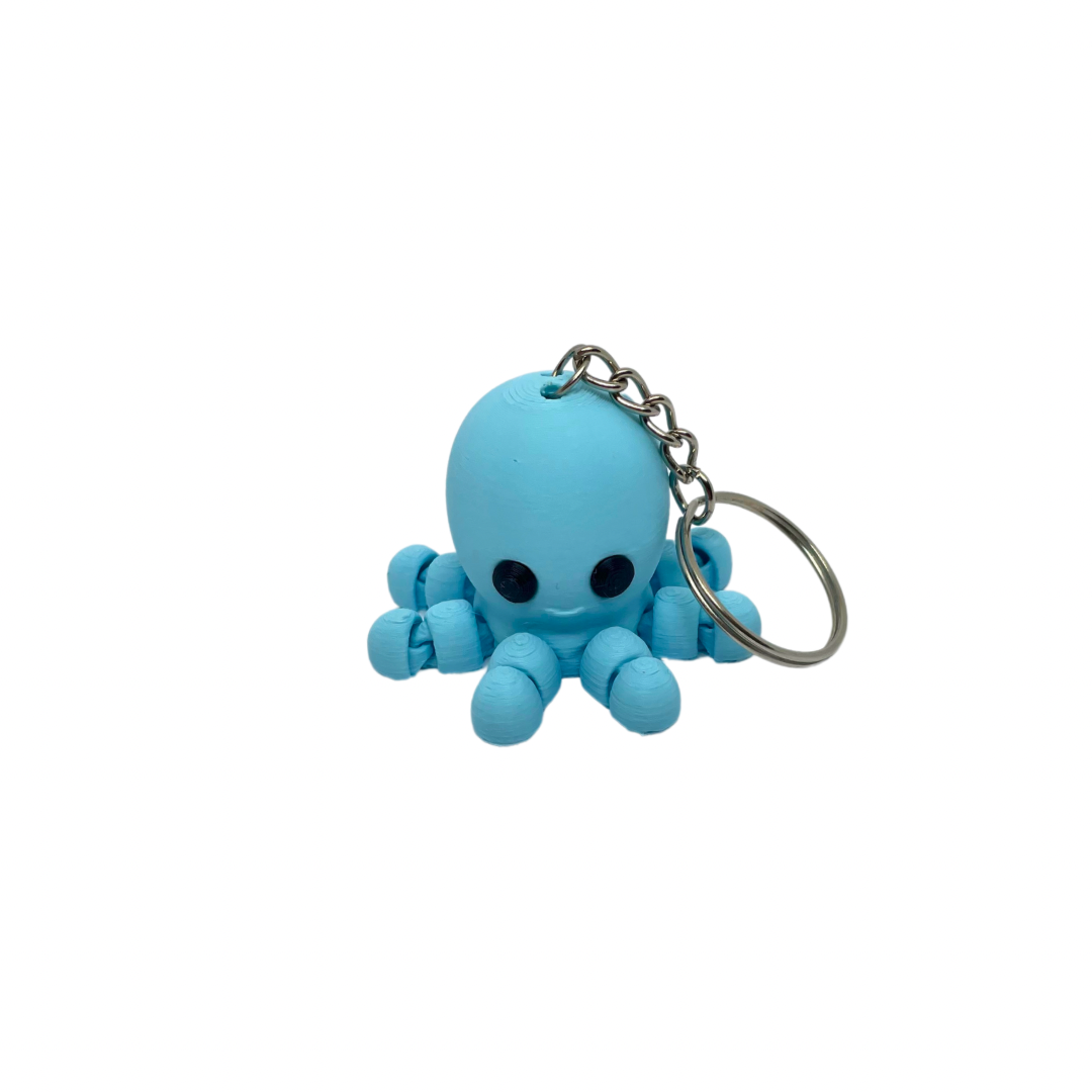 A baby blue octopus keyring with articulated tentacles and a metal keychain.