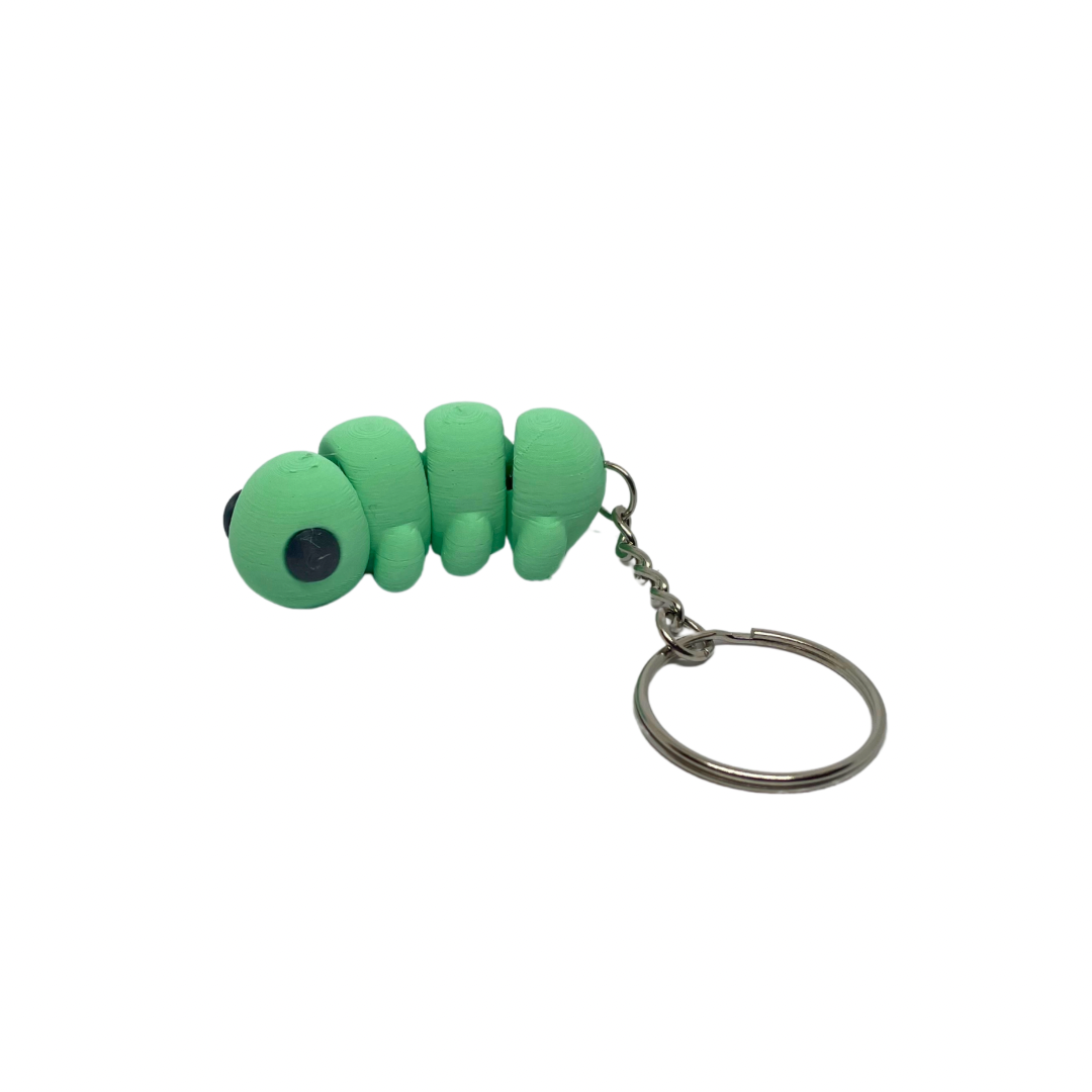 A green caterpillar-shaped keyring made from eco-friendly materials, displayed against a white background.
