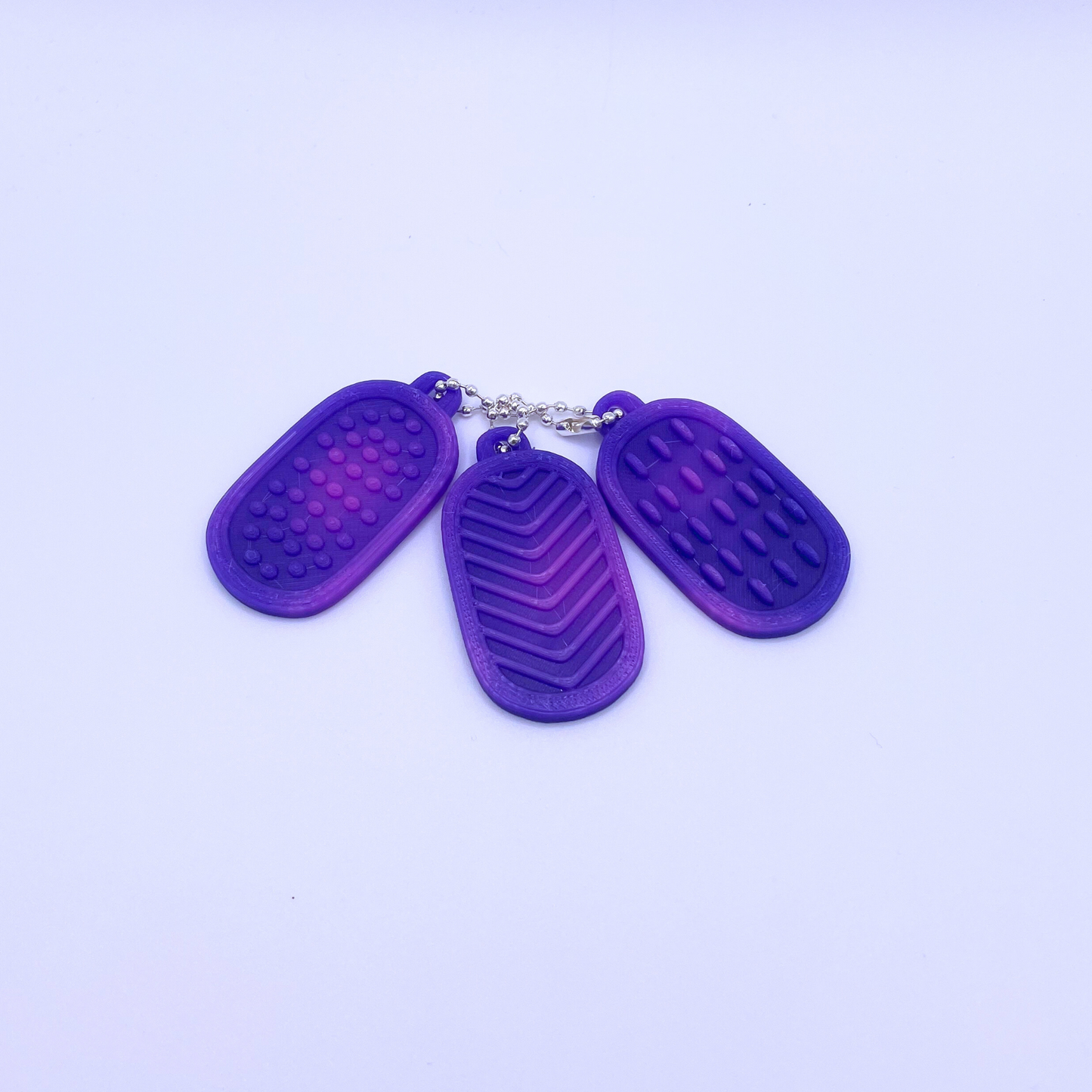 Set of three purple texture tags with different patterns, designed to change colour with heat.