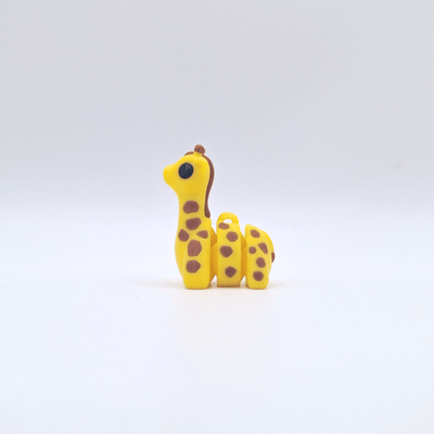 Yellow giraffe figurine with brown spots on a white background