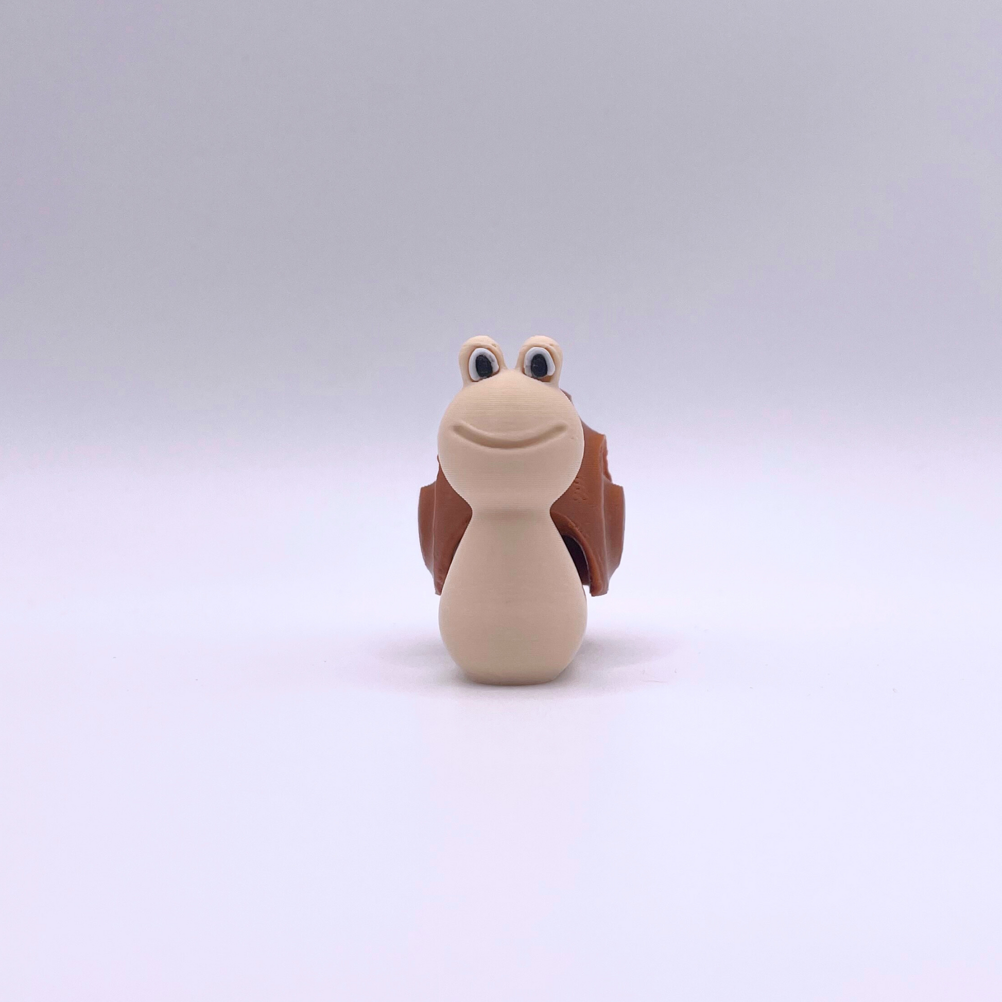 Brown and beige clicker snail fidget toy with smiling face, ideal for ASMR and sensory play.