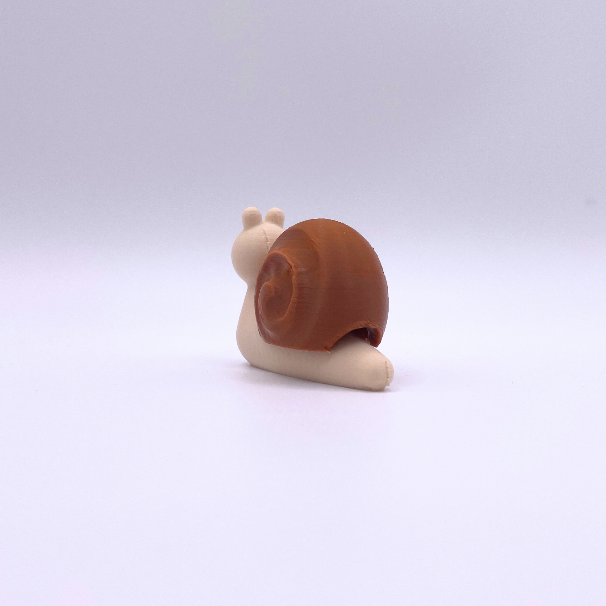 Brown and beige clicker snail fidget toy designed for relaxation and sensory play, featuring a ball chain.