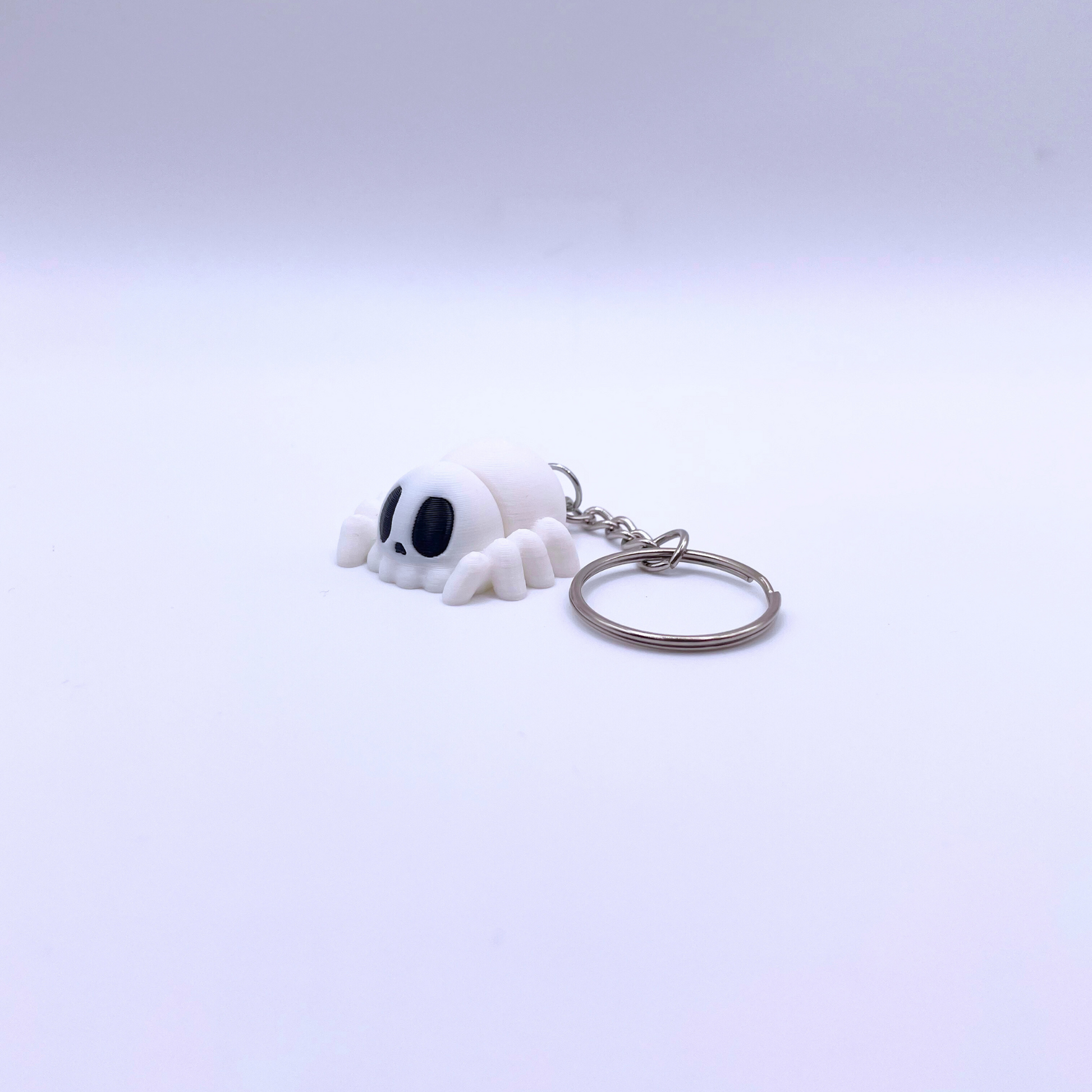 Mini white silk spider keyring with black eyes and keychain, perfect for Halloween decorations.