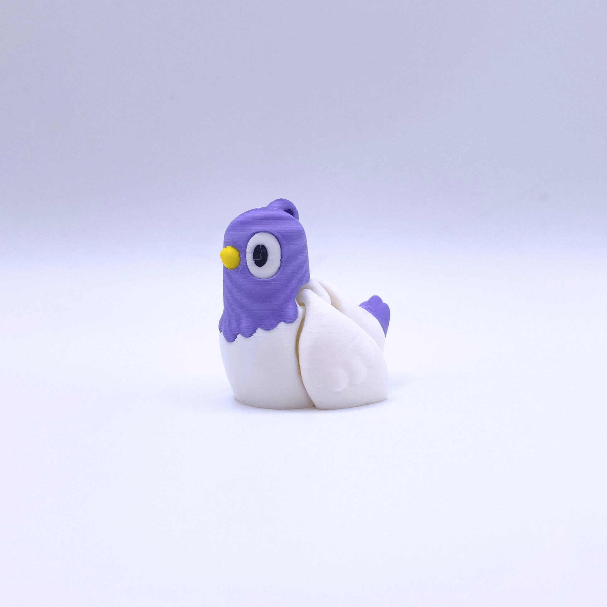 Toy pigeon with purple head and white body on a light gray background