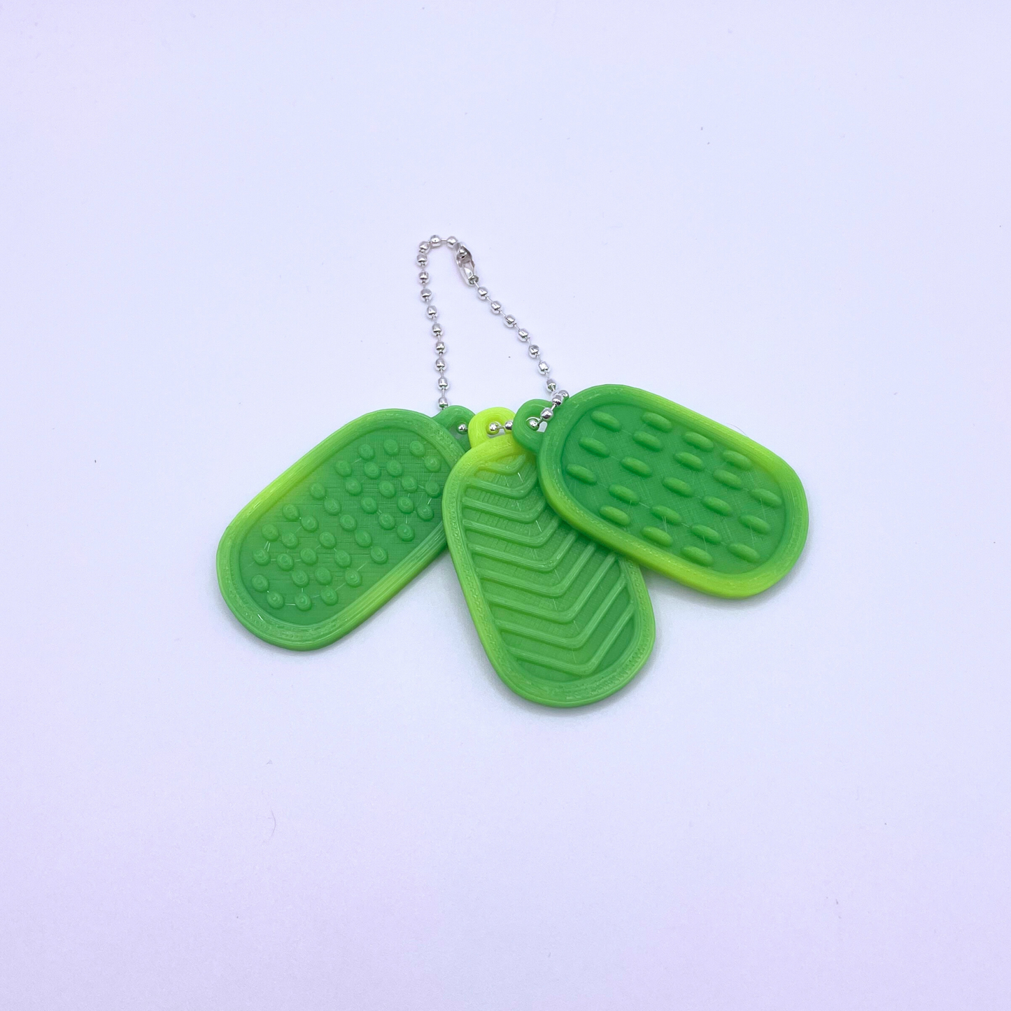 Set of three green texture tags with different patterns, designed to change colour with heat.