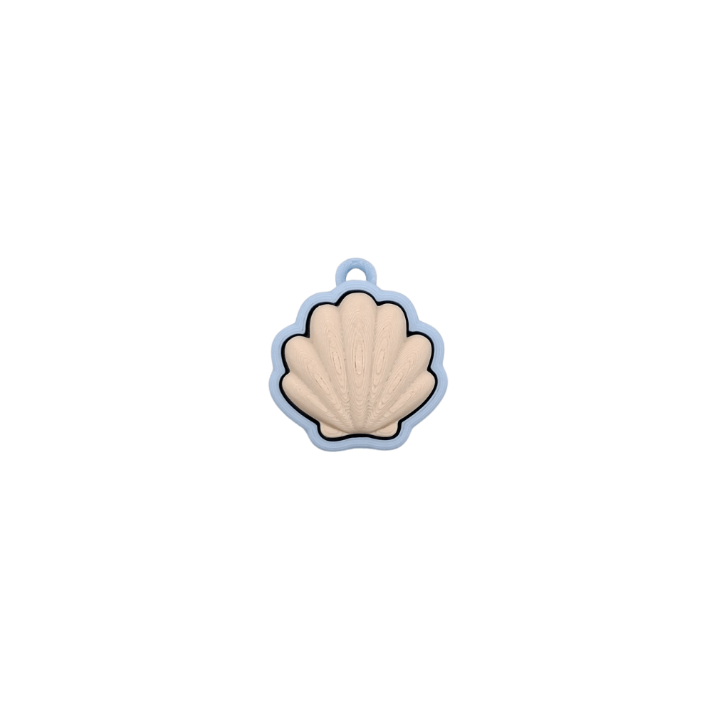 Shell Clicker in pastel blue and beige colors with a soft shell design and quiet click feature.