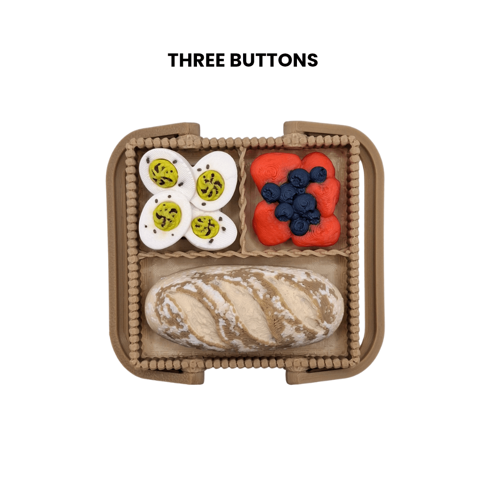 Toy lunch box with buttons containing food items on a white background