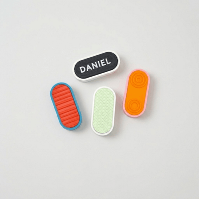 Custom Mag Slider customizable fidget buttons in various colors and textures on a neutral background.